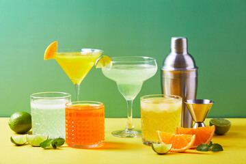 Multi-colored cocktails in glasses of different shapes on colored backgrounds with hard shadows