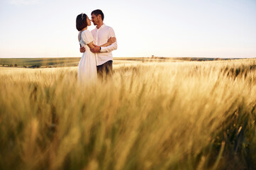 Standing and embracing. Couple just married. Together on the majestic agricultural field at sunny day