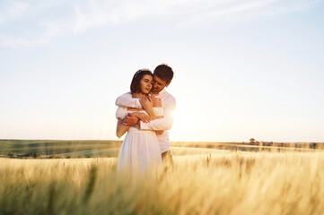 Against beautiful landscape. Couple just married. Together on the majestic agricultural field at sunny day