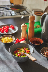 Sunliht modern kitchen with plate of quinoa filled with vegetables and ingredients on the countertop.