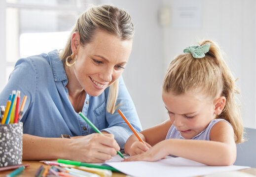 A happy mother, girl child drawing on paper and coloring together with pencils for preschool homework. Children in kindergarten, having fun being creative and learning creativity art skills from home
