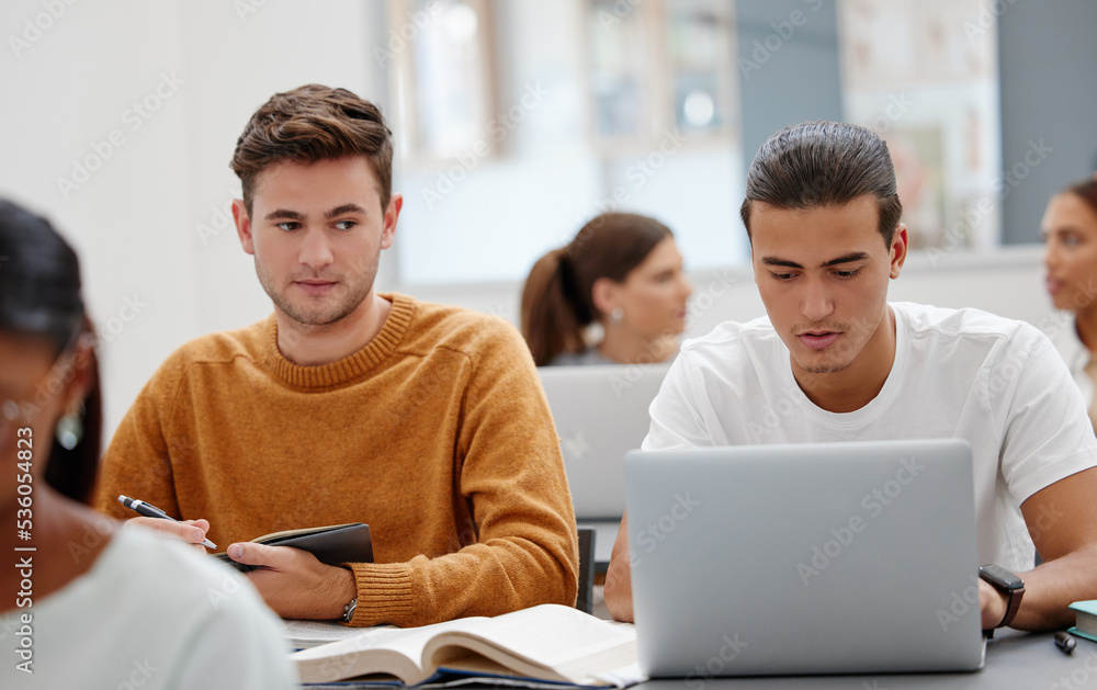 Poster Education, laptop and student cheating in classroom working on test, exam or research. University, learning and college man writing notes, assignment or busy peeping on friends computer in lecture.