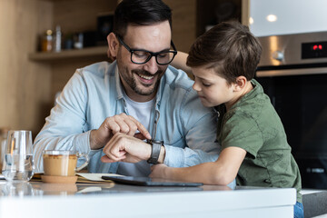 Father and son playing in kitchen, having a great family time!