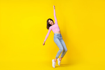 Full body photo of nice young girl raise arm hang hold invisible parasol dressed trendy striped...