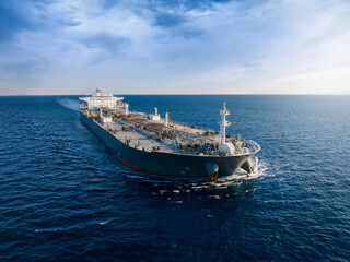Aerial front view of a heavy loaded crude oil cargo tanker in motion over blue ocean