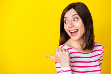 Closeup photo of young impressed attractive cute lady pointing looking empty space isolated on bright yellow color background