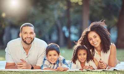 Relax, picnic and happy family rest together in a park, having fun and bonding on grass together. Love, smile and portrait of cheerful parents enjoy time in nature with excited and smiling kids