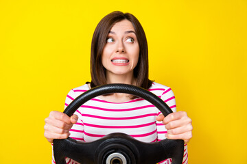 Photo of lovely young woman hold steering wheel failed driving lesson test dressed trendy striped look isolated on yellow color background