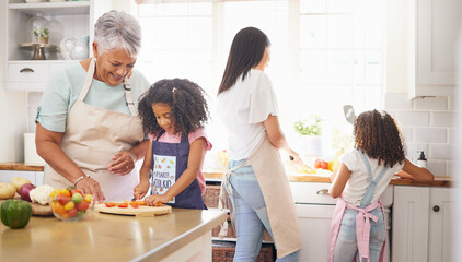 Black family cooking, children learning and grandmother teaching girl for healthy lunch and growth development in kitchen together. Senior woman and mom with kids make salad or vegetable food in home