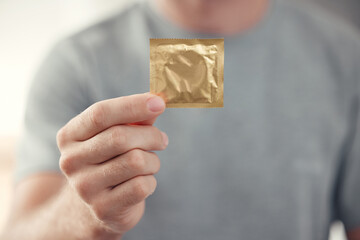 Condom in man hand for safe sex, sexual safety and hiv awareness zoom. Person with male...