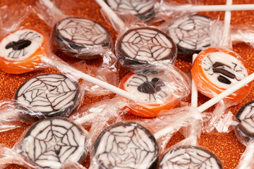 halloween candy with spiders and webs and glitter background