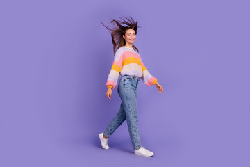 Full size profile photo of charming cheerful person flying hair walking isolated on violet color background