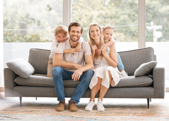 Happy, family smile and relax on living room sofa for holiday break together at home. Portrait of...