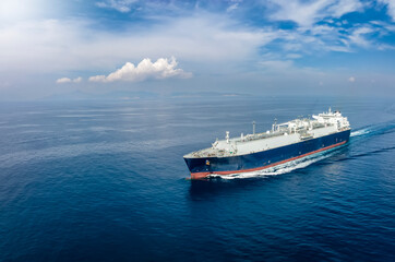 Front view of a big LNG tanker ship travelling over the calm, blue ocean as a concept for international fuel industry with copy space