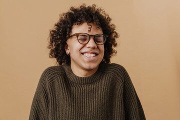 Young handsome curly smiling happy boy with closed eyes