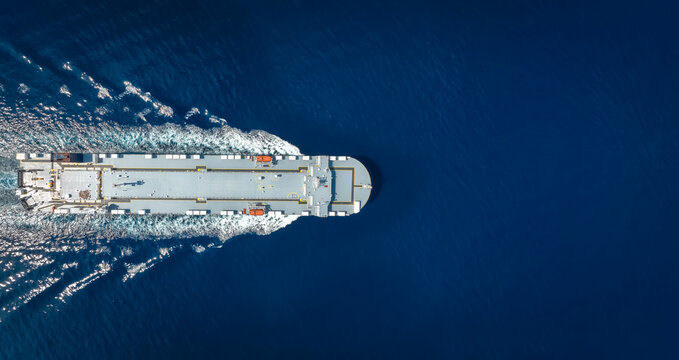 Aerial Top Down View Of A Big Car Carrier Ship RO-RO (Roll On Roll Off) Cruising In Mediterranean Sea As A Banner With Copy Pace