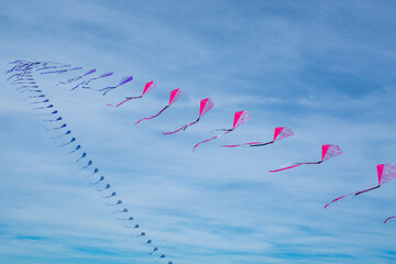 A row of colored kites in the sky