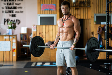 Fototapeta na wymiar Strong man lifting weights in a gym