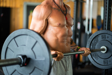 Unrecognizable man lifting weights in a gym