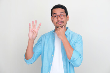 Adult Asian man showing curious face expression while giving four fingers sign