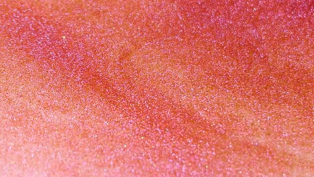 Defocused twinkling orange and pink ink. Abstract texture wallpaper/ background.