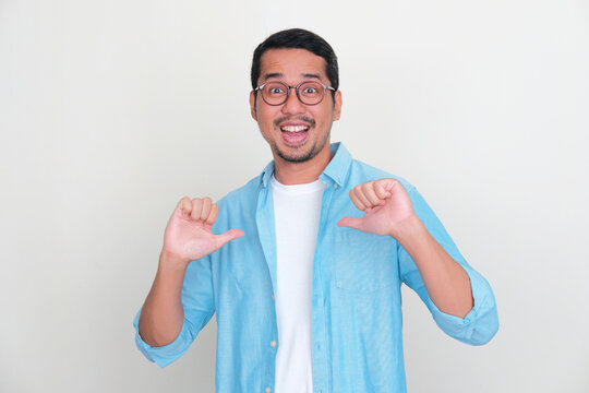 Adult Asian man pointing to himself with excited expression