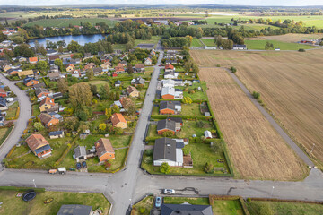 Aerial view on private houses situated close to a field. People and nature. Little European village. Modern village and a big field. Contrasts. 