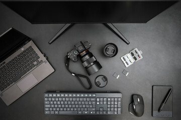 Top view of work space of photography with laptop, camera, monitor, graphic tablet and accessories.