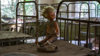 Plastic doll on rusty beds in abandoned kindergarten in city Pripyat near Chernobyl nuclear power...