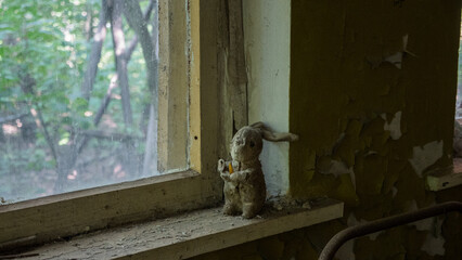 Soft toy rabbit on the windowsill in abandoned kindergarten in city Pripyat near Chernobyl nuclear power plant. Exclusion radioactive zone, ghost town, Ukraine. Radiation, catastrophe