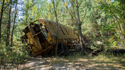 Destroyed abandoned bus in the middle of the forest in ghost city Pripyat after explosion fourth reactor Chernobyl nuclear power plant. Exclusion Zone. Ukraine. Radiation, catastrophe