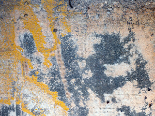 Texture photo of a wall with different colored stains and damages. Abstract grunge background.