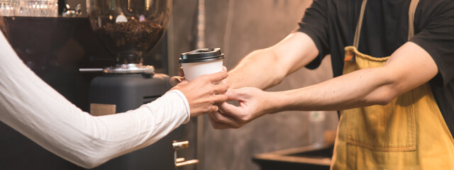 Close-up of hand Asian male barista serving coffee to customers in coffee shop Coffee business owner and coffee shop concept