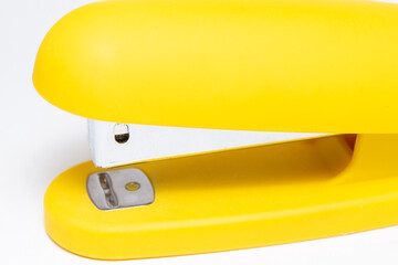 Yellow stationery paper stapler isolated on white background