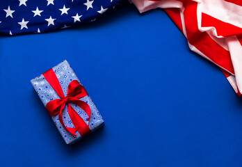 Happy Veterans Day concept. American flags with gift box against a blackboard background. November...