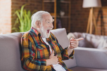 Photo of excited grandpa grey hair watching funny film tv program finger point wear casual...