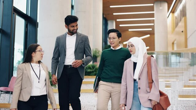 Group of colleagues in an office building discussing something

