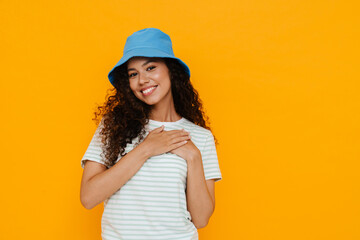 Naklejka premium White curly woman smiling and holding hands on her chest