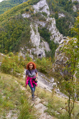 Naklejka premium Tourist with camera hiking on a trail