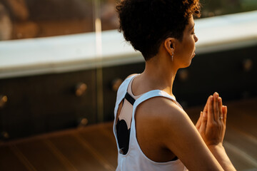 Young black woman practicing yoga at rooftop outdoors