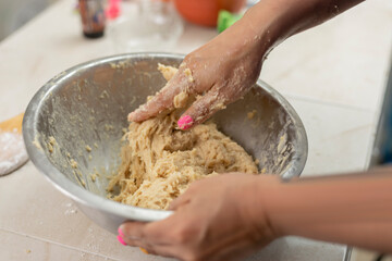 woman's hands kneading ingredients to make pan de muerto