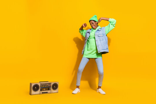 Full size photo of funny overjoyed person have fun clubbing vintage boom box isolated on yellow color background