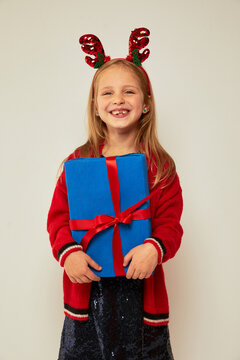 Smiling funny child (kid, girl)  holding Christmas gift box