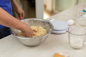 woman's hands kneading ingredients to make pan de muerto