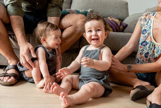 Cheerful Diverse Family With Adorable Little Twins Sitting On Floor At Home