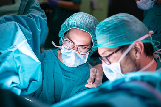 Surgeon and assistant preparing tools