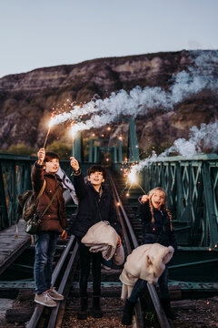 Group of young friends with sparkles on a bridge