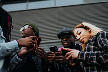 Black friends using smartphones on street