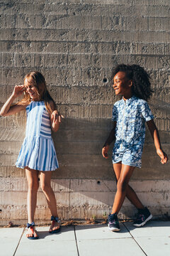 Cheerful diverse girls having fun on street in sunlight