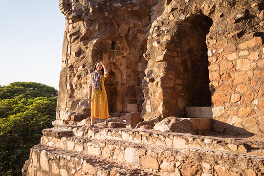 Happy ethnic tourist outside old village building